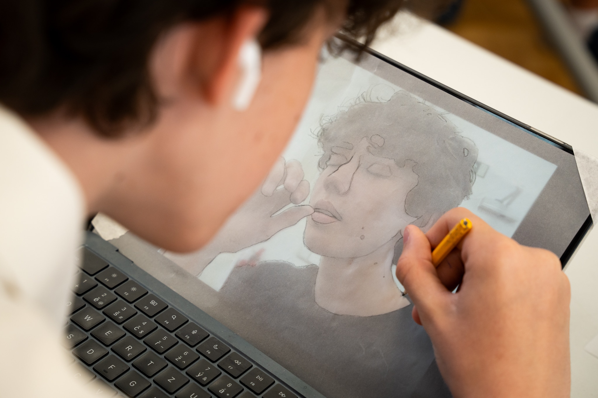 A student drawing a portrait on a tablet