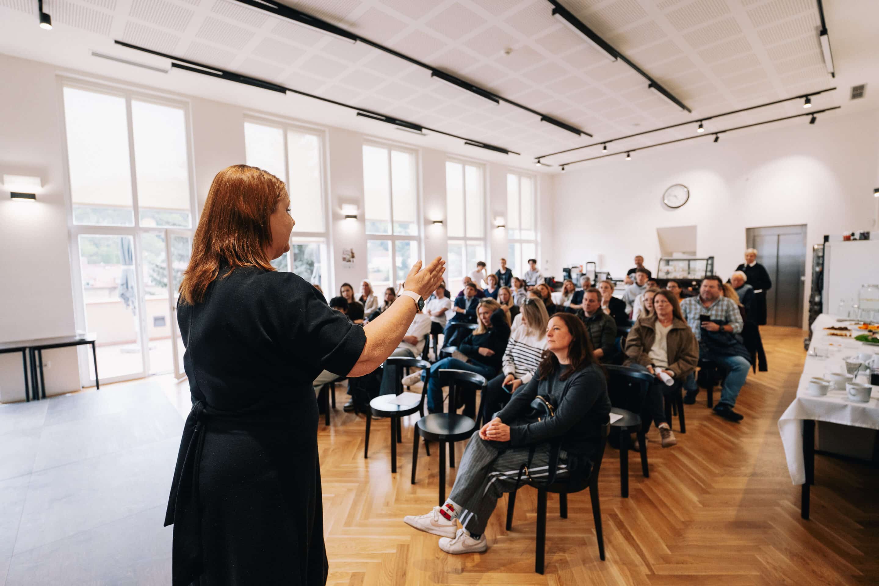 A teacher speaking to a full hall of students